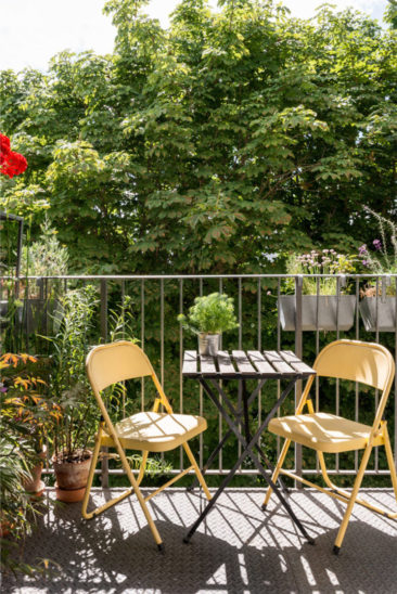 Aménager un balcon plein de charme - Une petite table bistrot avec des chaises de jardin dépareillées colorées