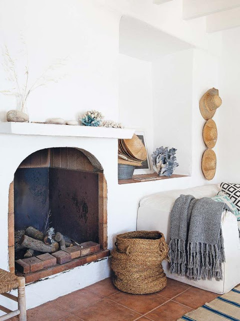 Une maison de pêcheur, rénovée par Jessica Bataille à Alicante // Tapis rayé en blanc et bleu et coussins ethniques, collection de chapeaux de paille