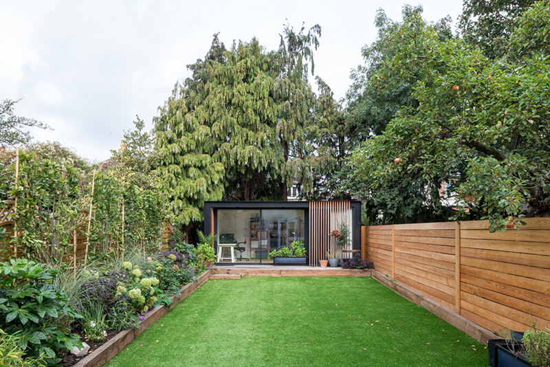 Une maison londonienne à l'intérieur familiale et design // On notera la cabane en préfabriqué au fond du jardin, qui sert de bureau