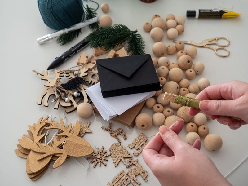 Un calendrier de l'avent maison - Guirlande improvisée avec des perles de bois et des enveloppes à retrouver sur le site staceystachetti.com