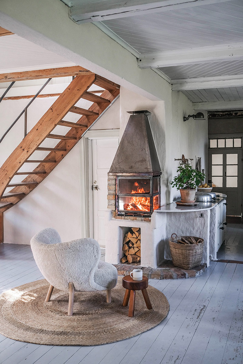 Le style scandi rustique et industriel en déco // La maison en suède du duo d'Our food stories - Petit coin cosy avec son poêle à bois et son fauteuil scandinave