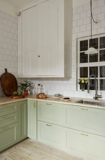 Un appartement ancien à Stockholm, plein de charme - Cuisine suédoise, avec placards verts d'eau et faïence blanche posée en quinconce jusqu'au plafond