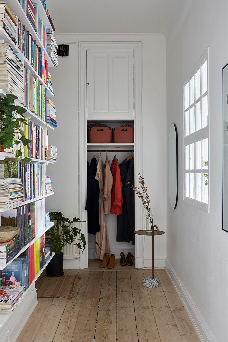 Un appartement ancien à Stockholm, plein de charme - Entrée avec bibliothèque basique et placard