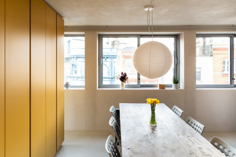 L'aménagement d'un appartement tout en longueur // La chambre et la salle à manger, séparées par un meuble sur-mesure jaune