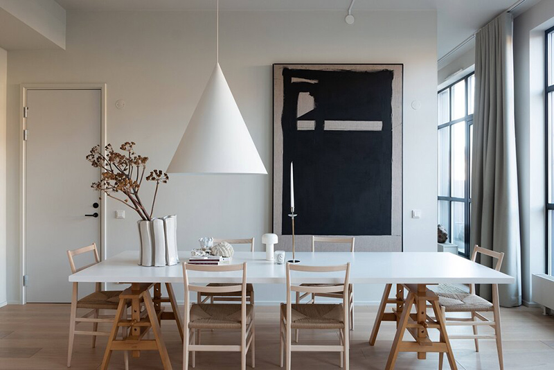 Le loft de Lotta Agaton, une grande table de salle à manger blanche et ses chaises design en bois