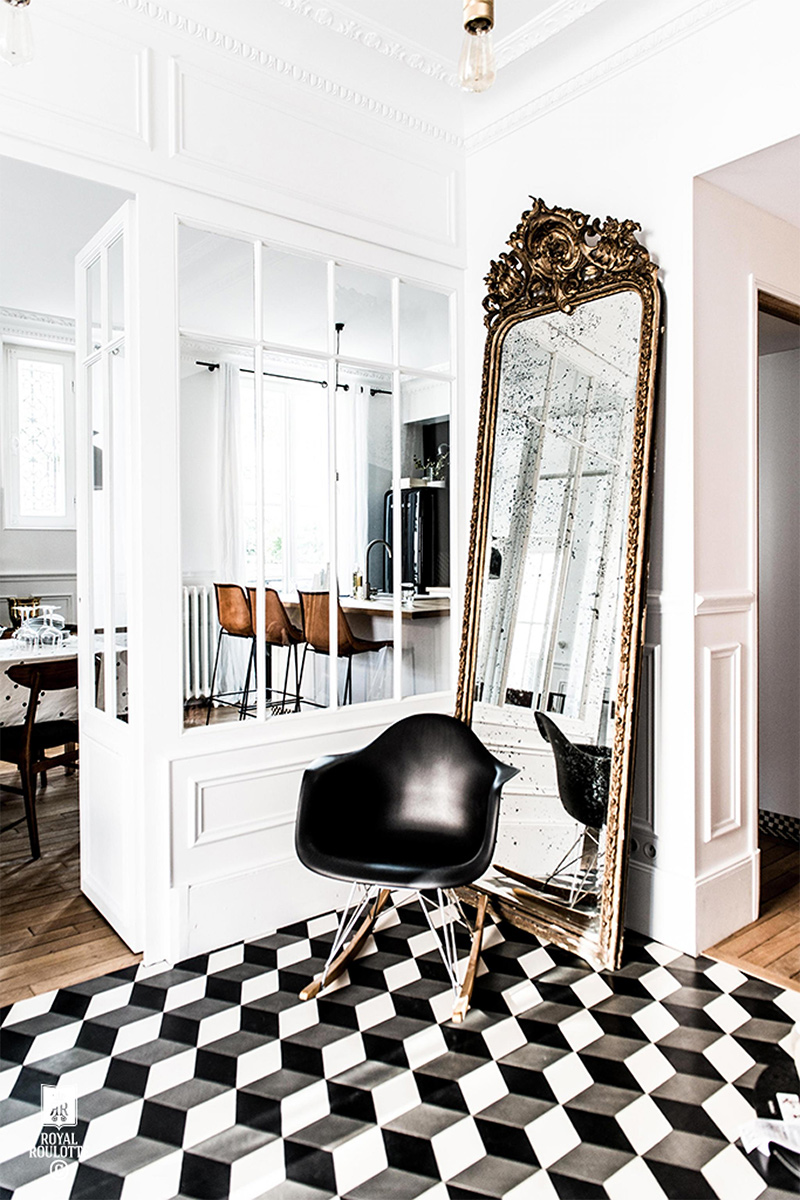 Un grand miroir trumeau posé à même le sol dans une entrée en carreaux de ciment noir et blanc par Royal roulotte