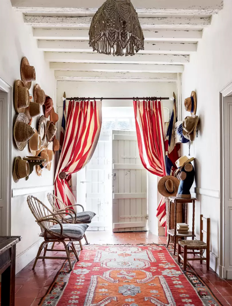 Une maison de campagne bohème avec un rideau d'entrée théatrale à rayures rouge et blanc