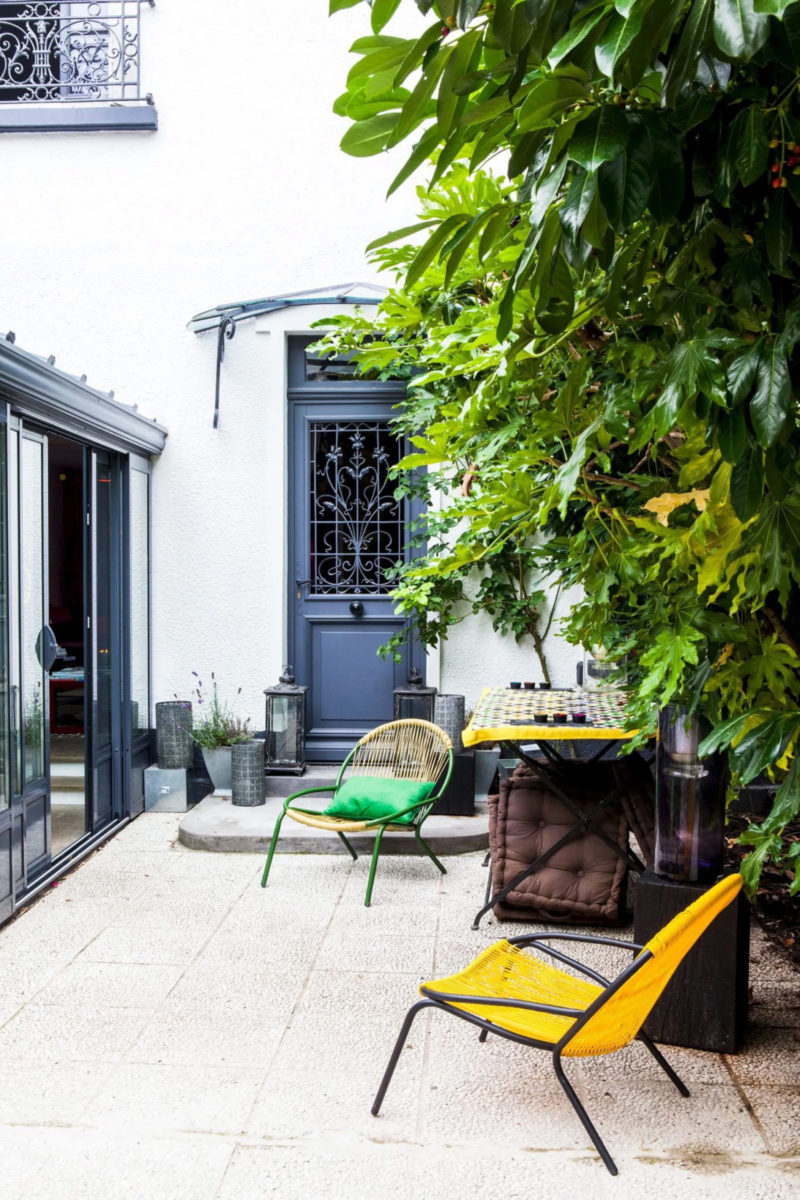 Une terrasse de pavillon de banlieue parisienne avec des sièges en corde colorés