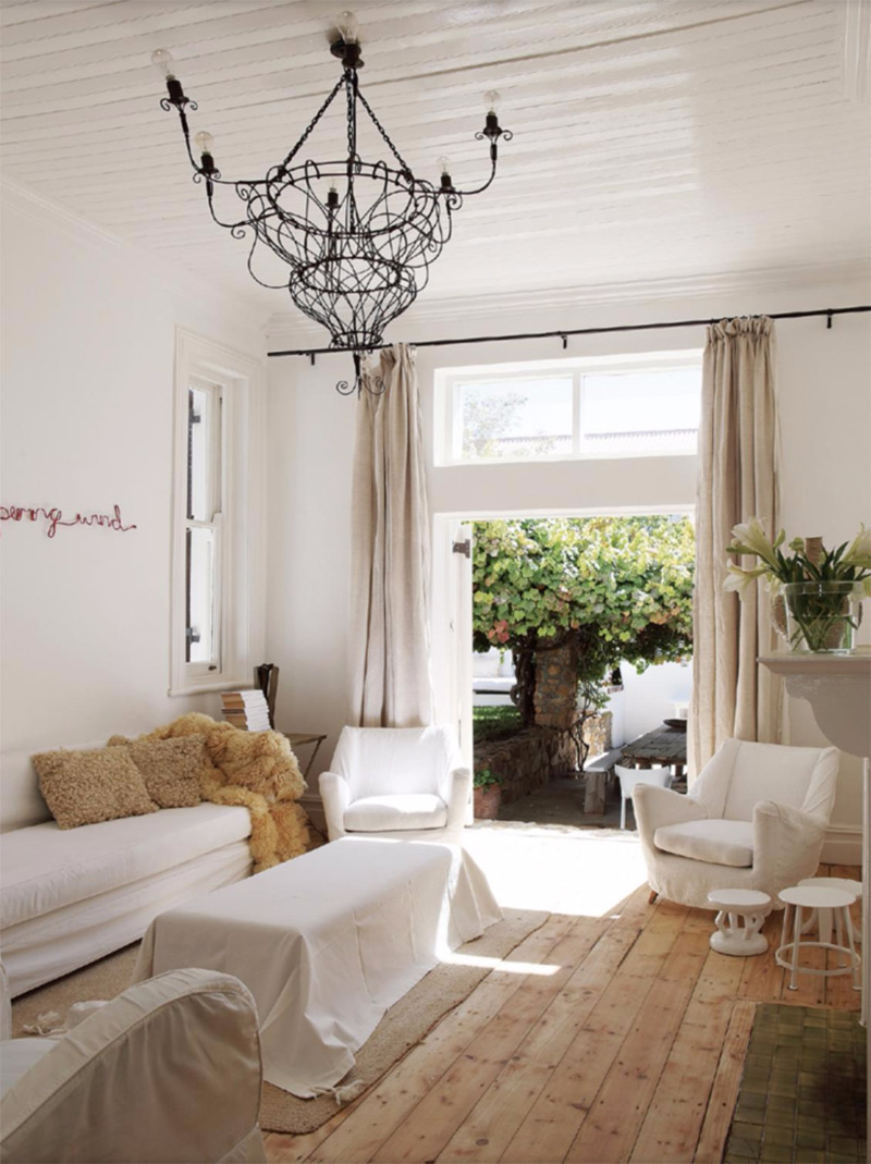 Un salon, décoré en camaïeu de blanc, dans une vieille maison de Captown avec un plancher d'origine