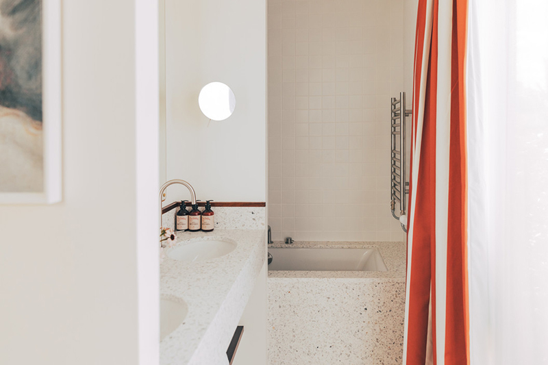 Hôtel Wallace Paris 15, signé Hauvette & Madani // Salle de bain en terrazzo et rideaux à rayures rouge et blanc