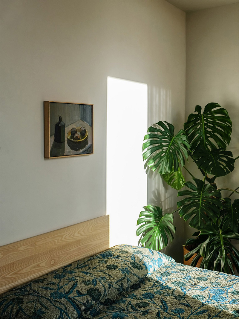 Une chambre minimaliste réchauffée par quelques éléments décoratifs verts