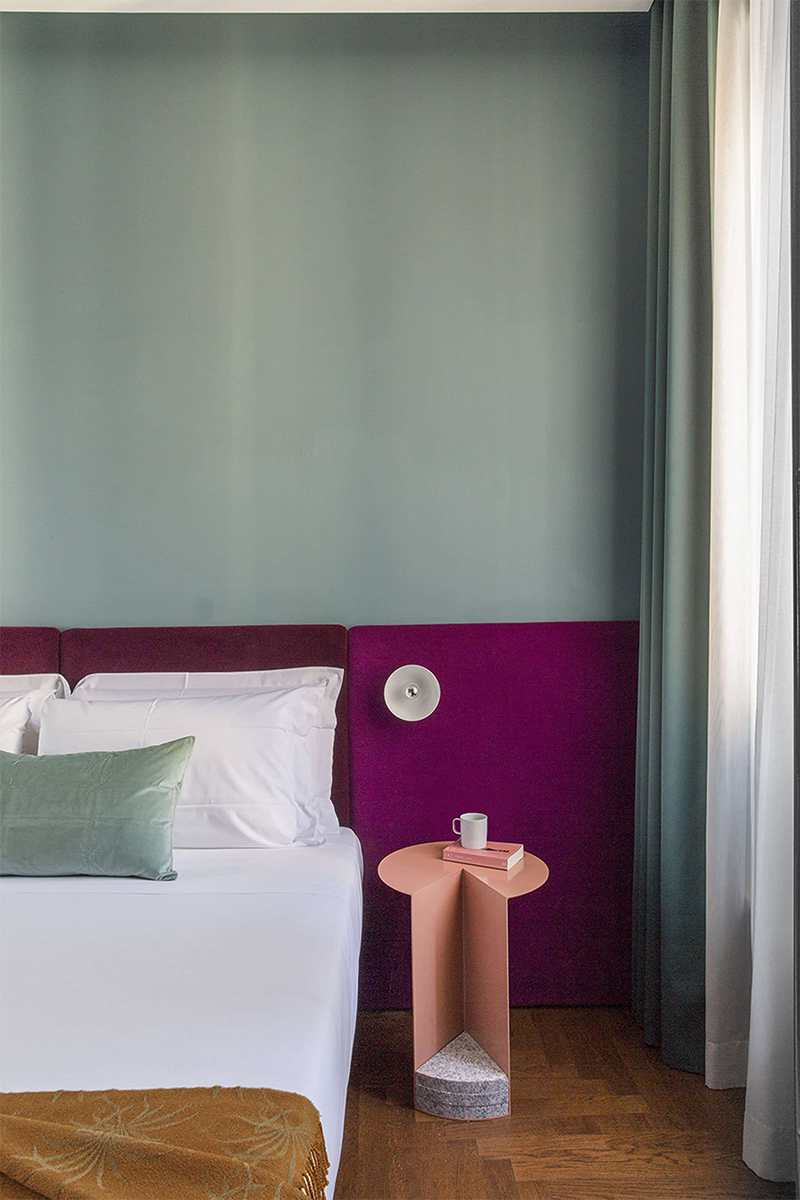 Hôtel Condominio Monti à Rome avec une tête de lit violete sur mur vert d'eau