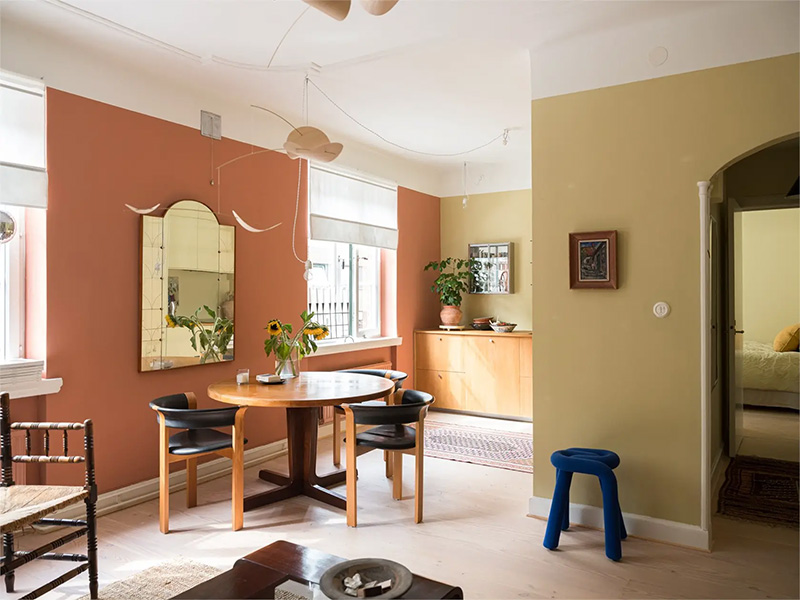 Un salon peint avec un mur terracotta et un autre jaune paille