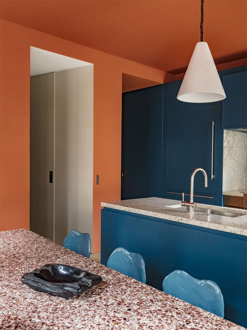 Une cuisine, combinant des murs terracotta et du bleu paon