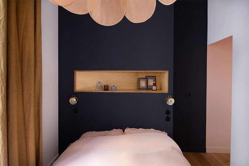 Une micor chambre avec une tête de lit noir associé à une combinaison de rose assourdi