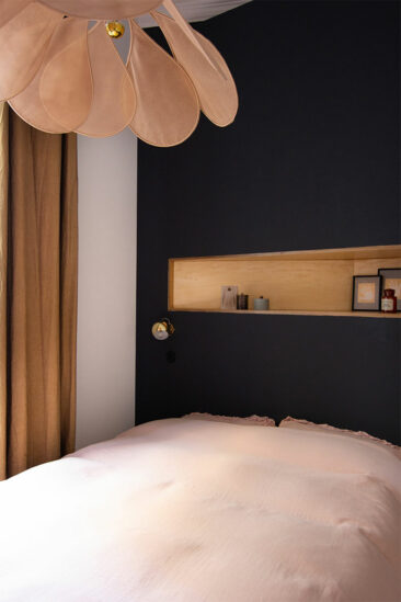 Une micor chambre avec une tête de lit noir associé à une combinaison de rose assourdi