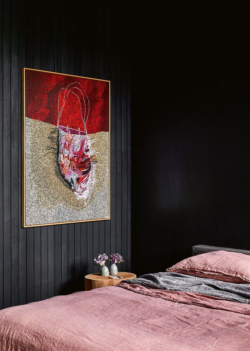 Une chambre en total look noire, réveillée par du rose et rouge