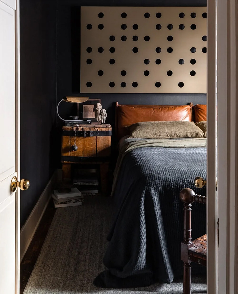 Une chambre noire chaleureuse grâce à des matières chaudes comme le cuir, le bois, le lin
