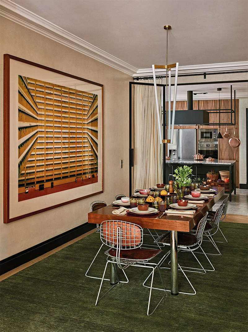 Une salle à manger vintage avec un tapis vert avocat et des éléments bruns