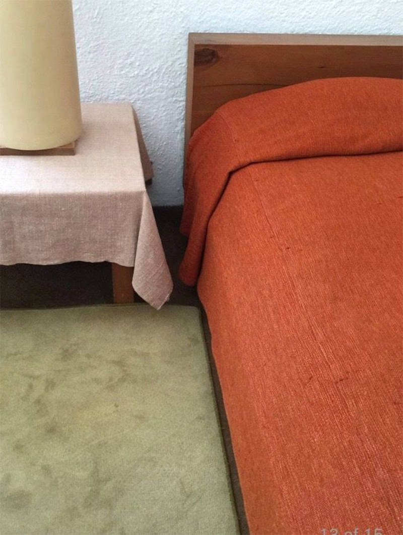 Chambre rétro seventies avec sa moquette vert avocat et son dessus de lit orange brique