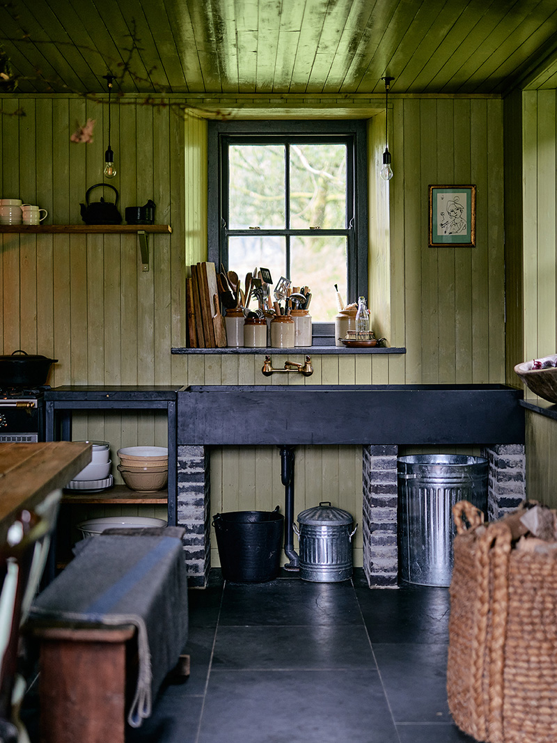 Une cuisine de style rustique avec un lambris vert et sol en ardoise