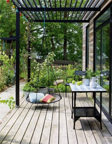Une terrasse en bois avec pergola noire dans un esprit nature