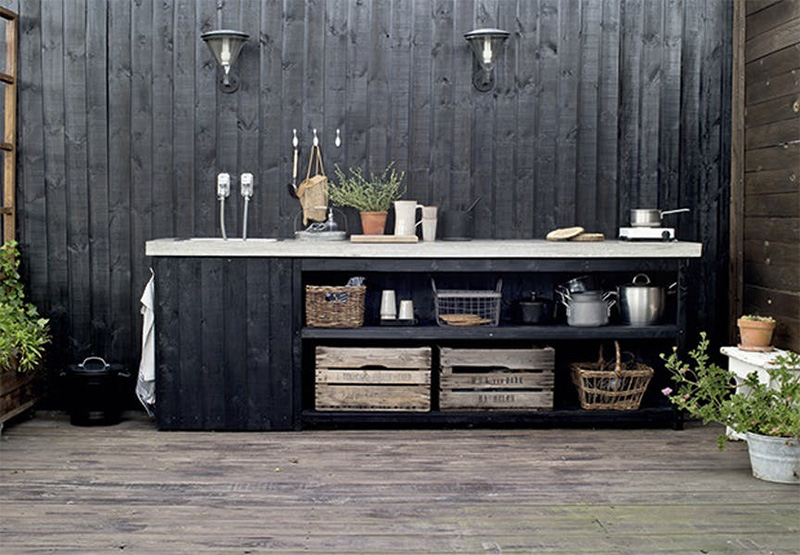 Une cuisine en bois aménagée à l'extérieur en Suède