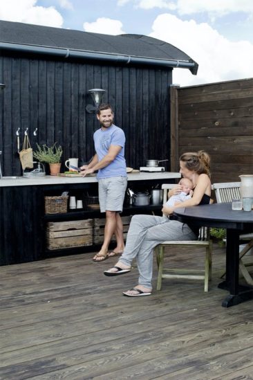 Une cuisine en bois aménagée à l'extérieur en Suède
