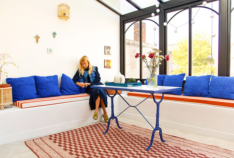 Un hymne aux couleurs éclatates, chez Salomé à Paris. Un hymne aux couleurs éclatates, chez Salomé à Paris. Coussins outremer, matelas rayés blanc et rouge, et petite déco de vacances
