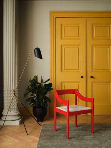 Une chaise rouge vermillon, accentué par la présence de vert doux