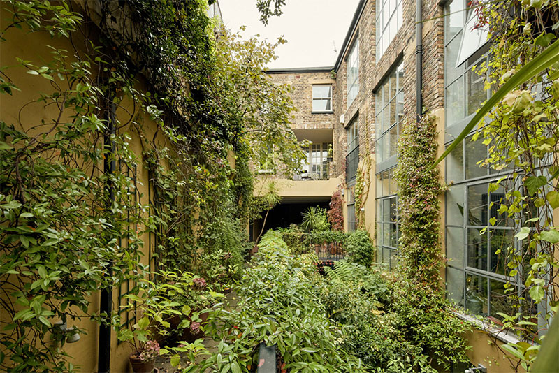 Une cour d'entrepôt en briques converti en jardin verdoyant