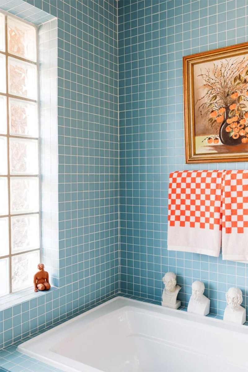 Une salle de bain aqua et ses accessoires rouges