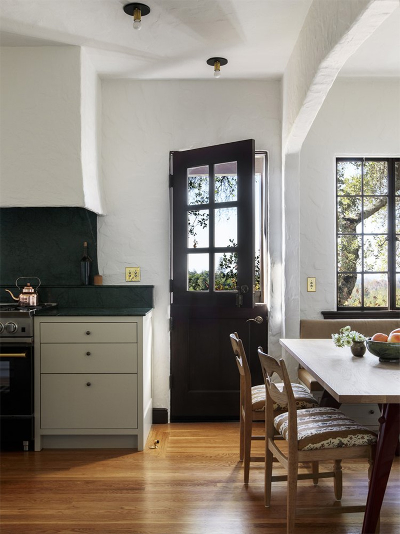 Une cuisine ancienne en noir et blanc avec un beau parquet vernis