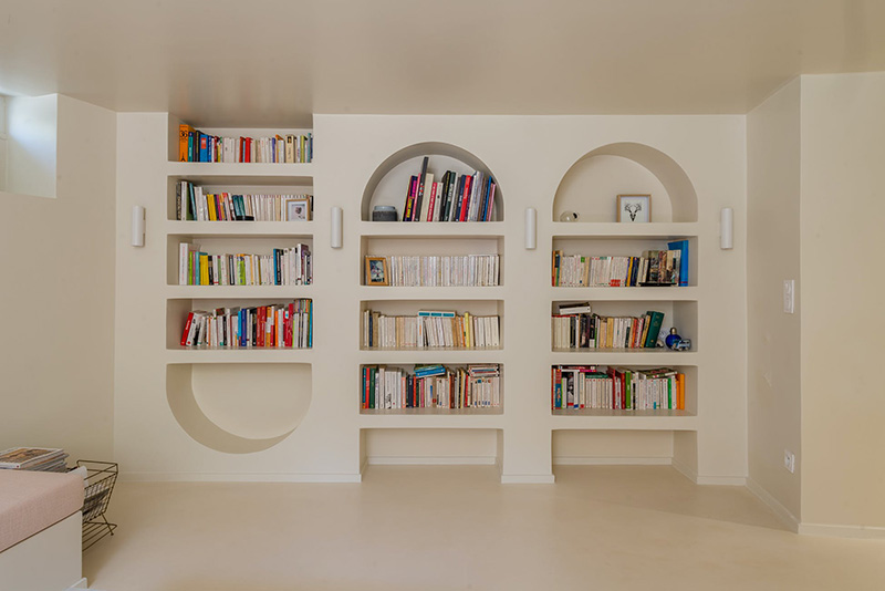 Bibliothèques "arches" en plâtre, aménagés dans le sous-sol de la maison