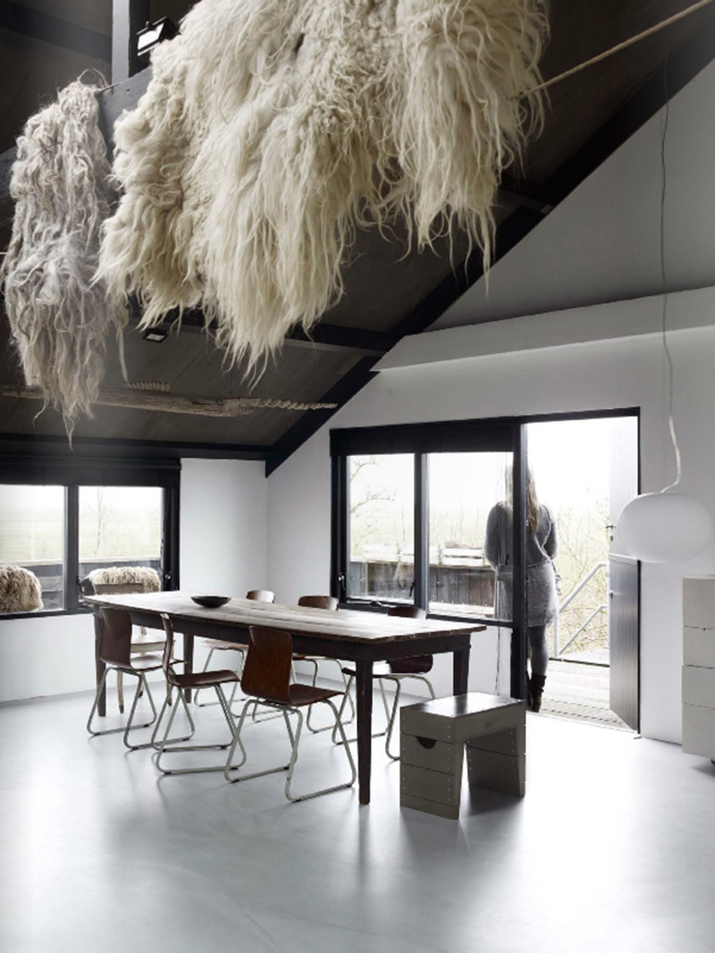 Un grand séjour moderne avec un sol en béton ciré gris clair et plafond noir