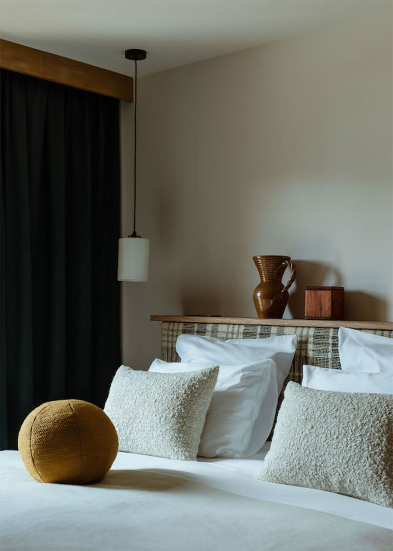 Une chambre au look vintage moderne avec une tête de lit tartan et des coussins en tissu bouclé // Chalet 1550 Courchevel par Iconic House