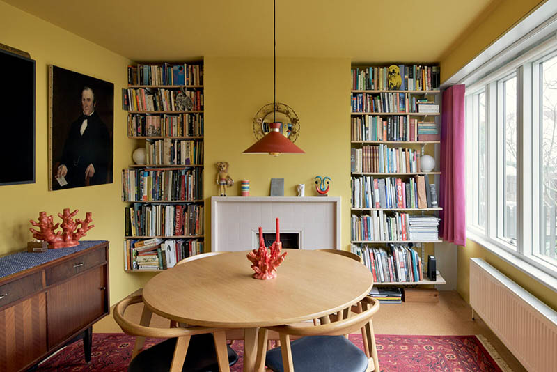 Une salle à manger peinte dans un jaune ocre murs et plafonds, meublée de mobilier de brocante