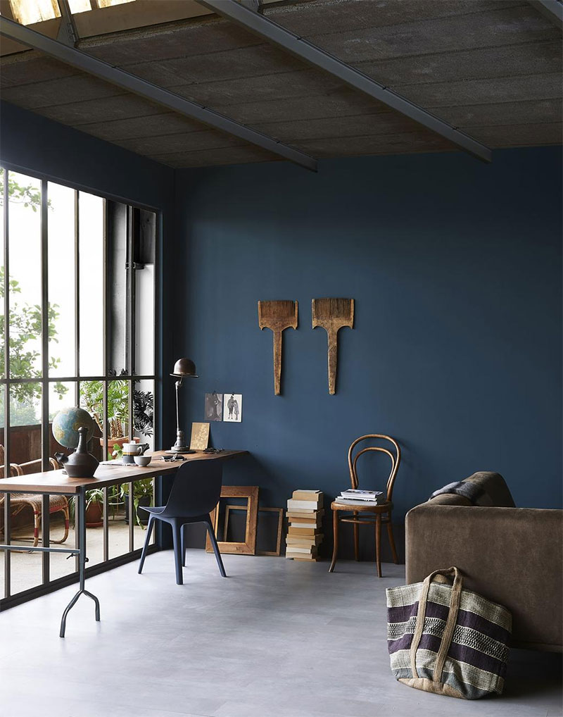 Une pièce à vivre "atelier" monchrome bleu avec un sol gris