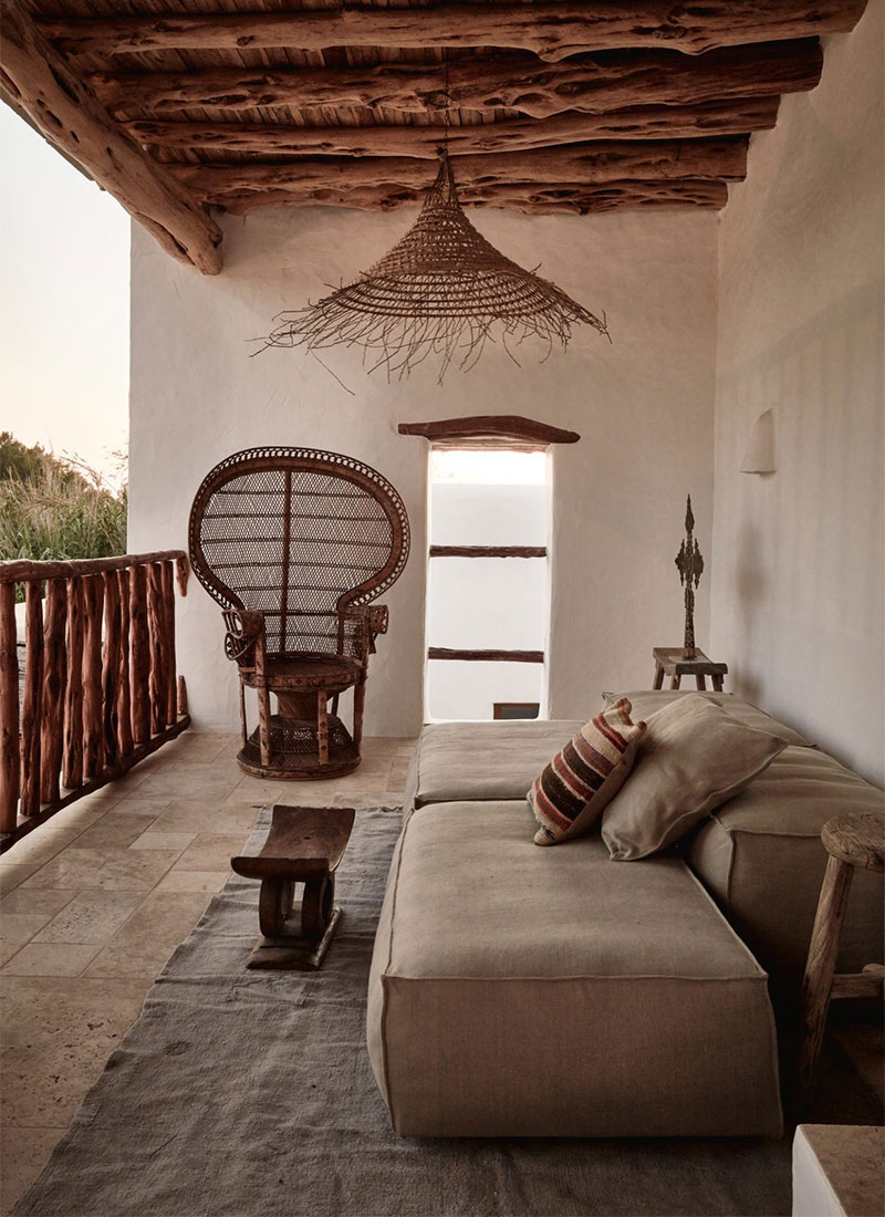 Un balcon de maison à Ibiza, aménagé dans un style bohème naturel