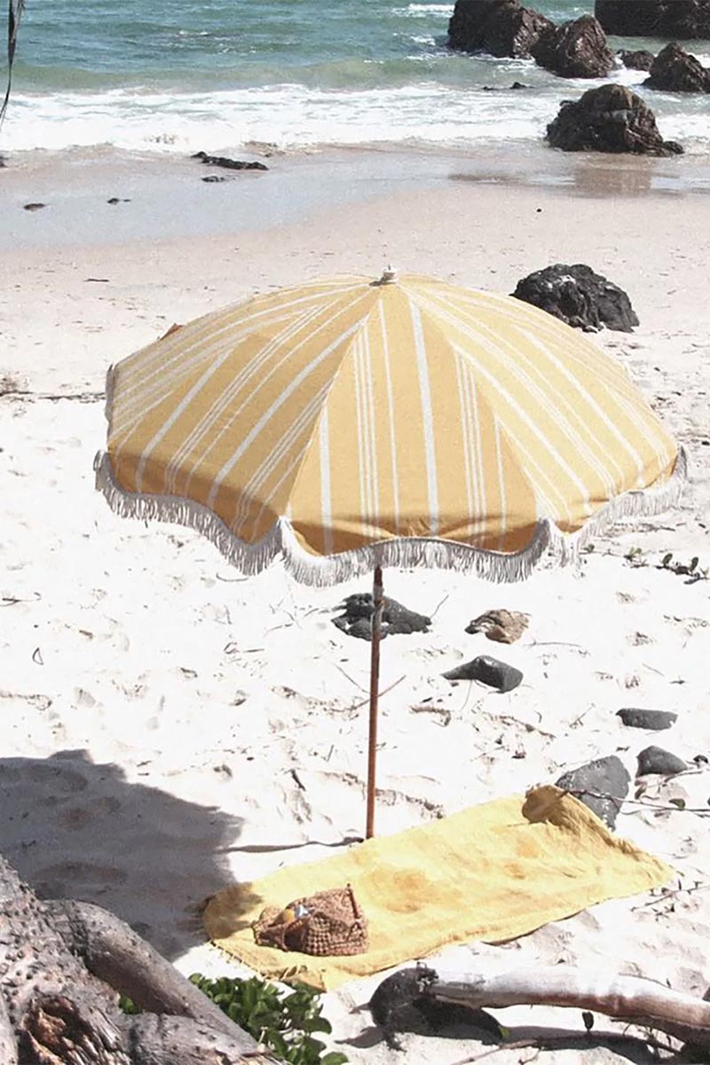 Parasol jaune à rayures blanches rétro sur la plage - Catalogue Business & Pleasure Co