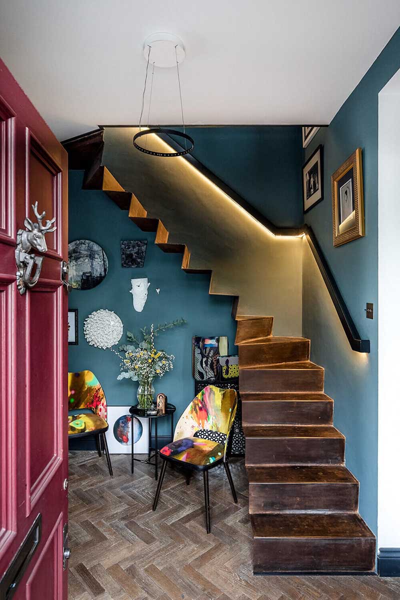 Une entrée bleue avec un escalier en acier plié