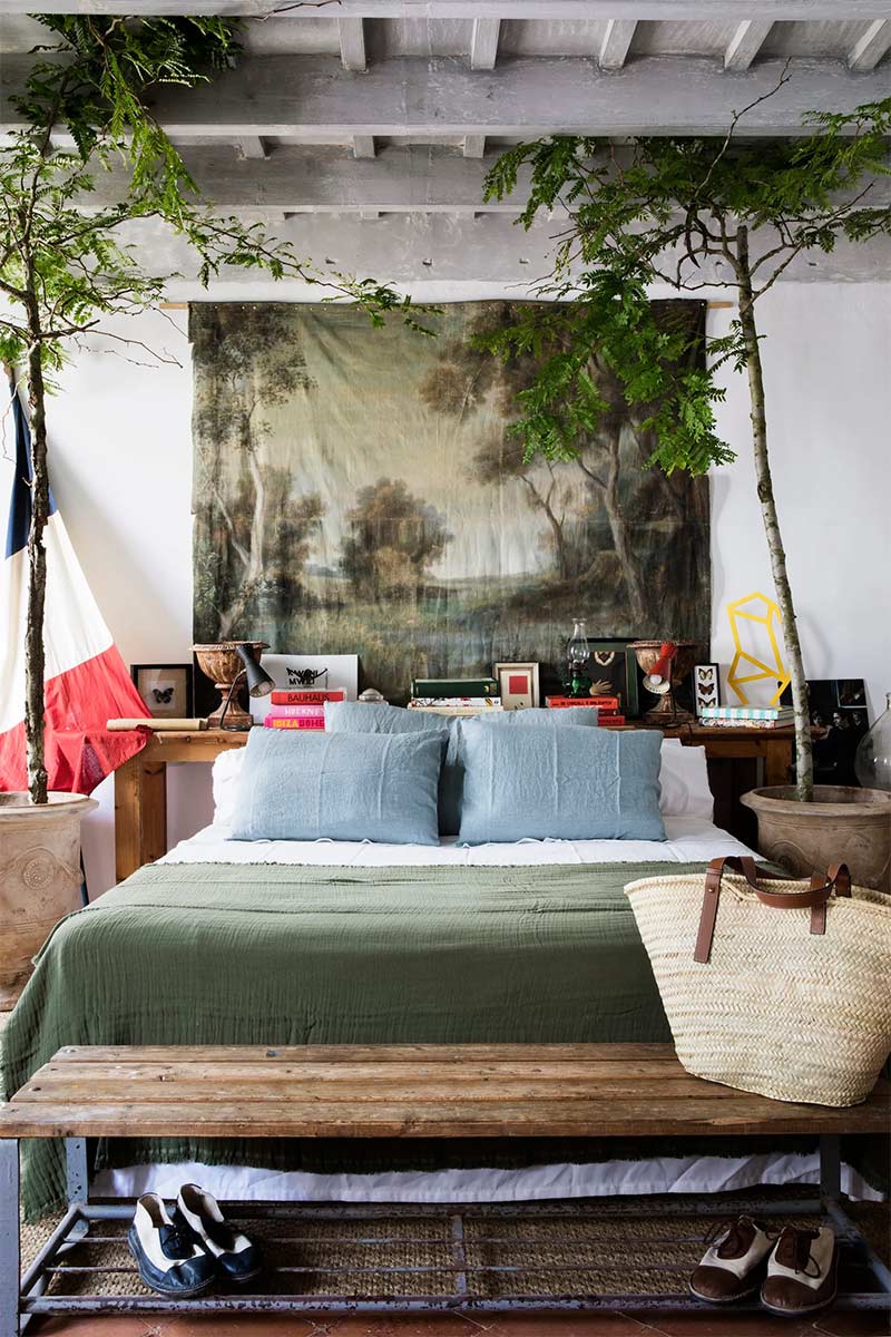 Une tenture impression tapisserie ancienne derrière un lit