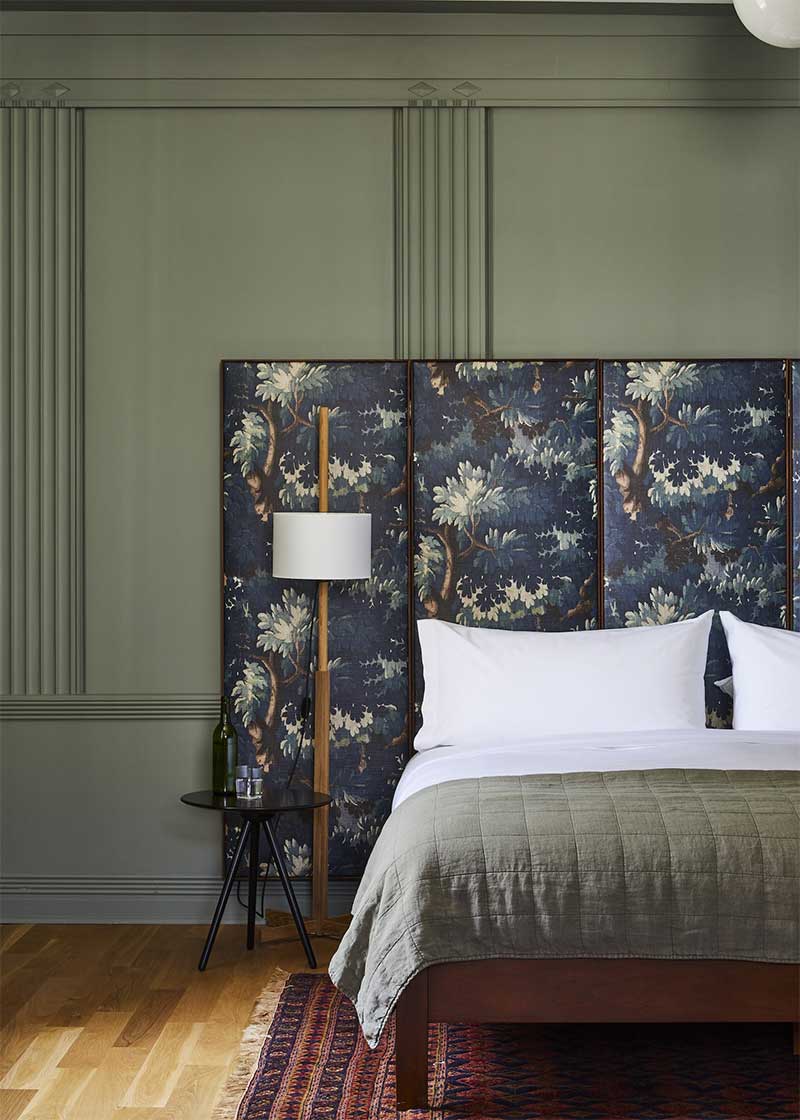 Chambre avec tête de lit rélisasée avec un tissu aux motifs inspirés des tapisseries anciennes d'Aubusson