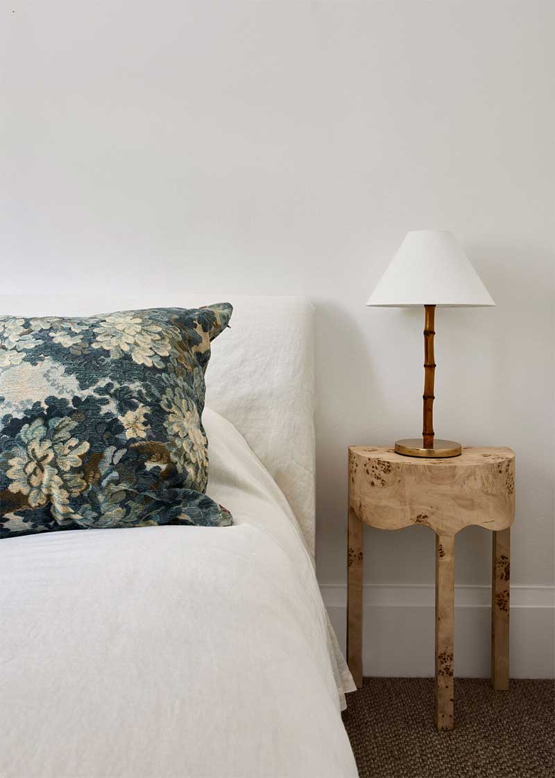 Un coussin en tapisserie Aubusson dans une chambre épurée et minimaliste