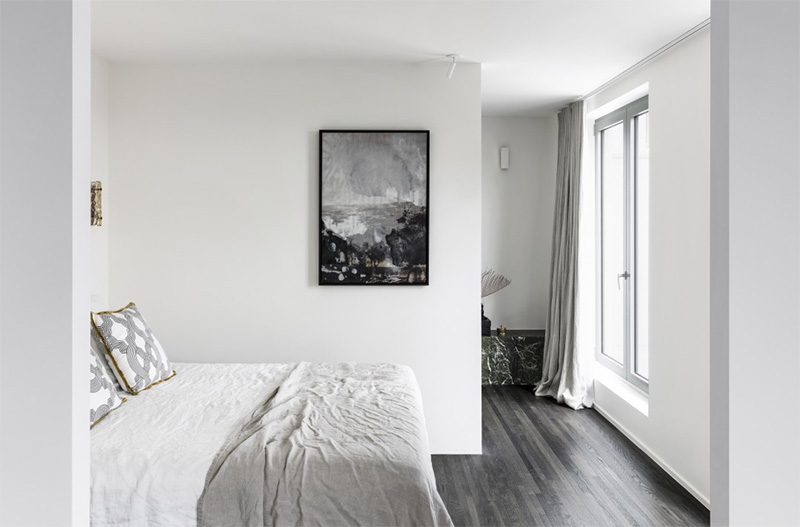 Un appartement au décor contemporain minimaliste, réchauffé de rideaux en lin