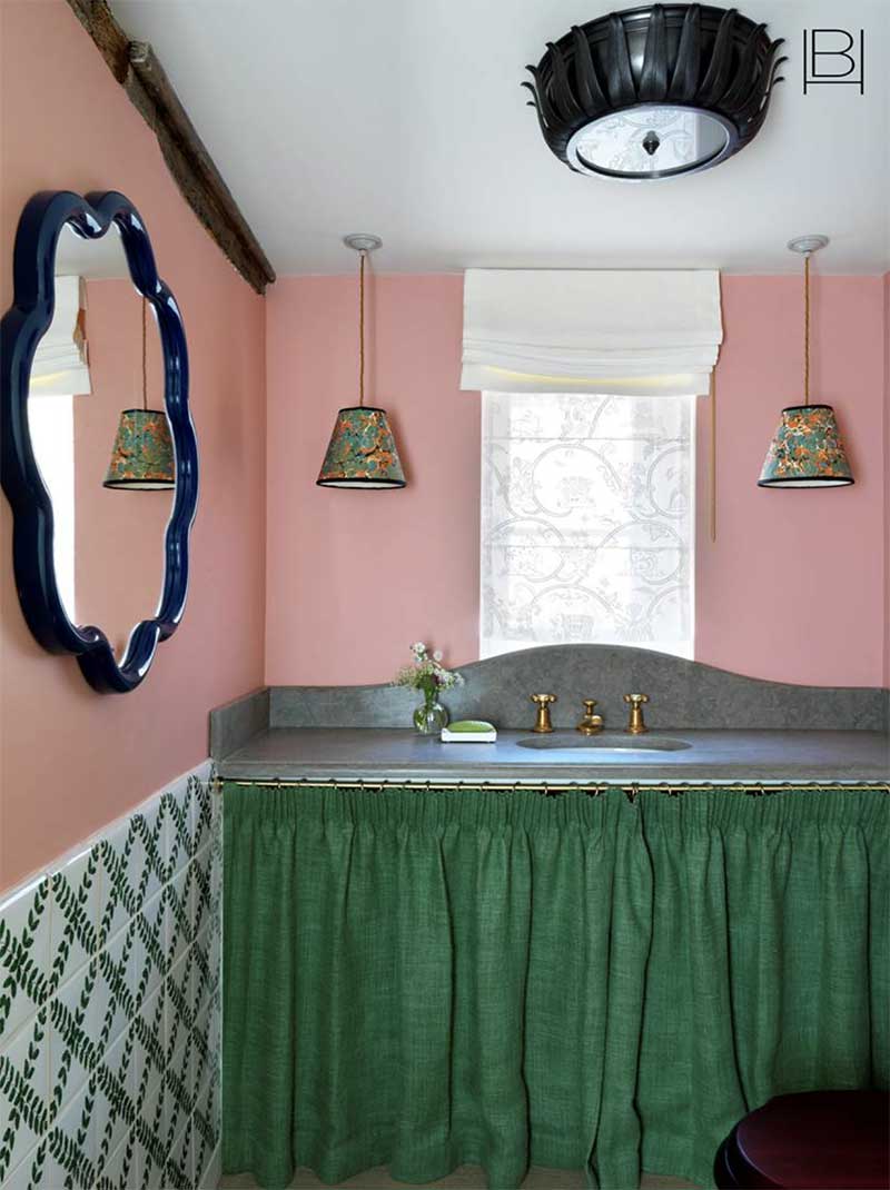 Un lavabo masqué par un rideau vert par Beata Heuman dans un style fantaisiste anglais
