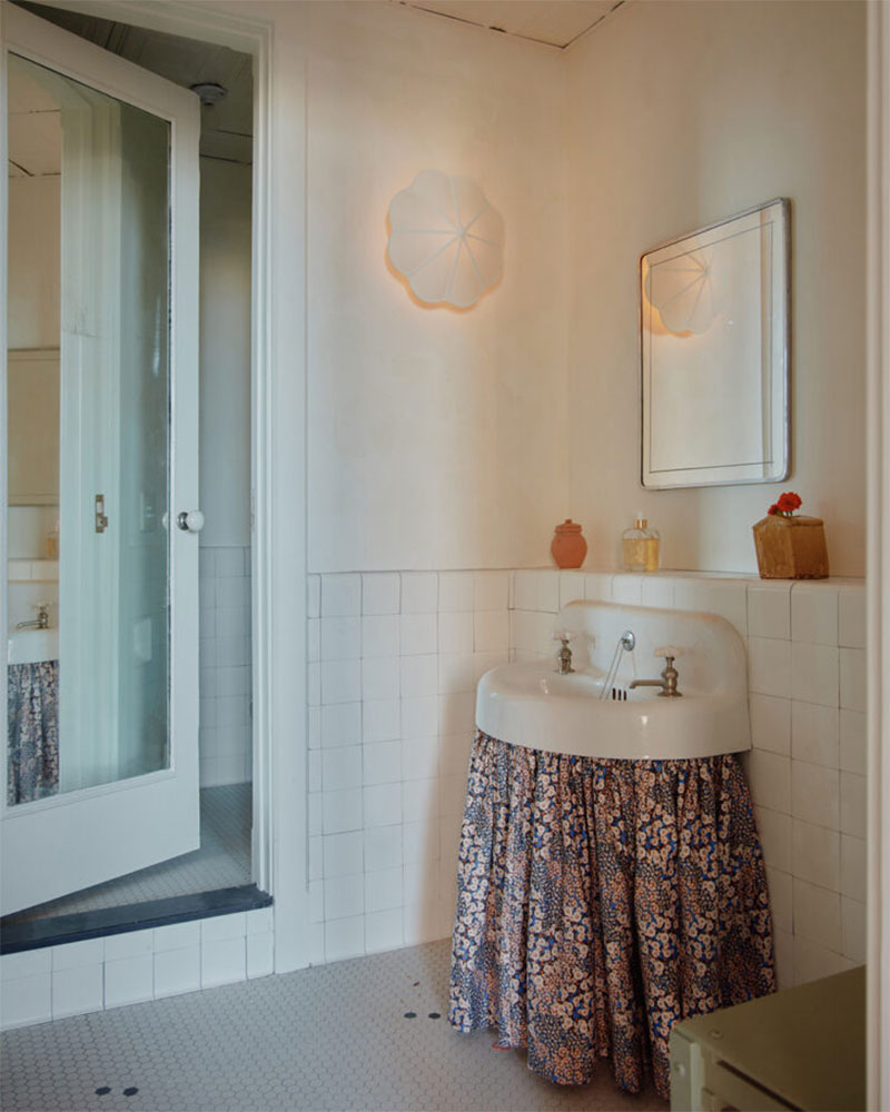 Un rideau jupon pour un look vintage dasn cette salle d'eau