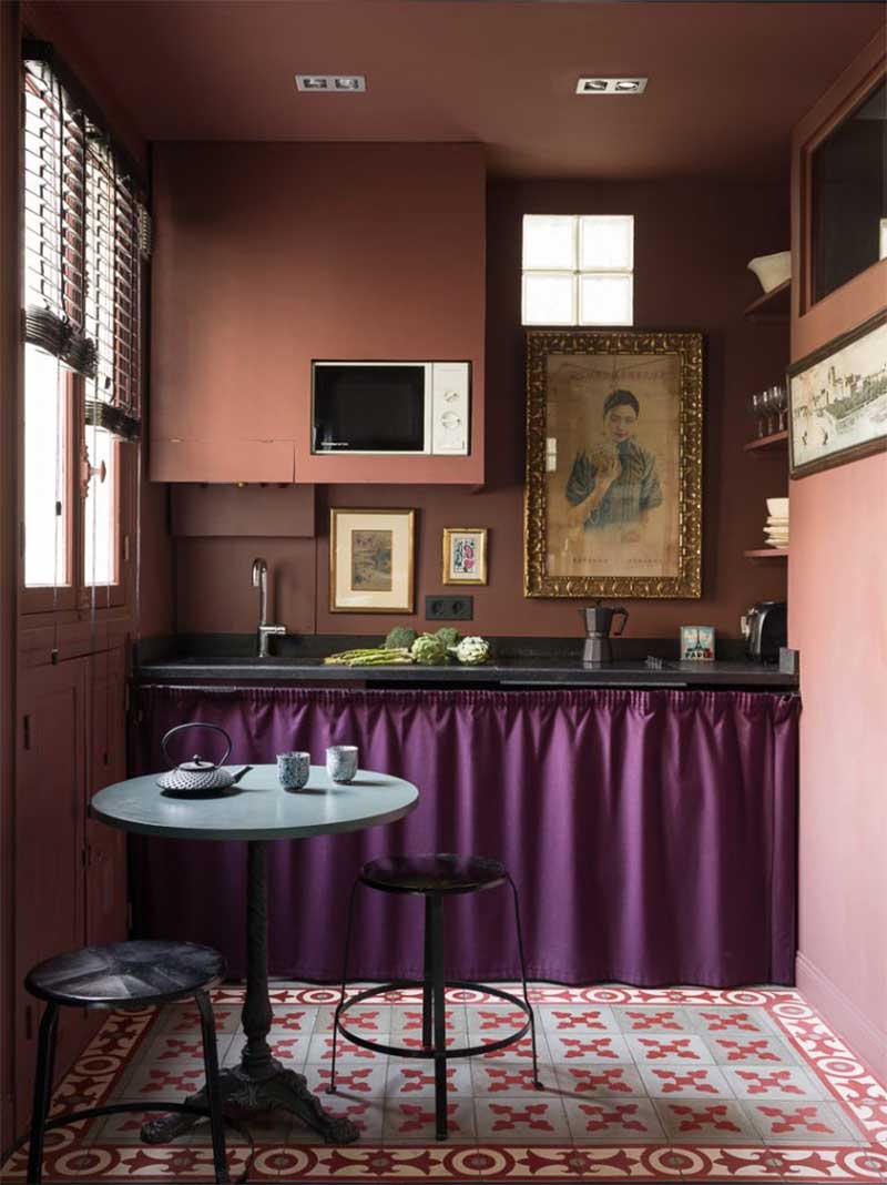 Une petite cuisine monochrome terracotta avec un rideau de placard violet