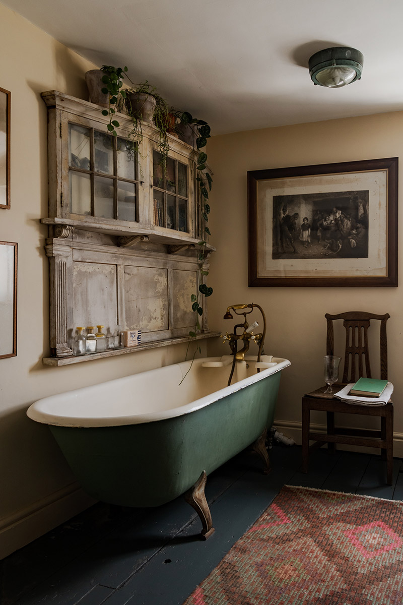 Une salle de bains avec sa baignoire sabot et la mise en scène d'antiquités pour un style "old new"