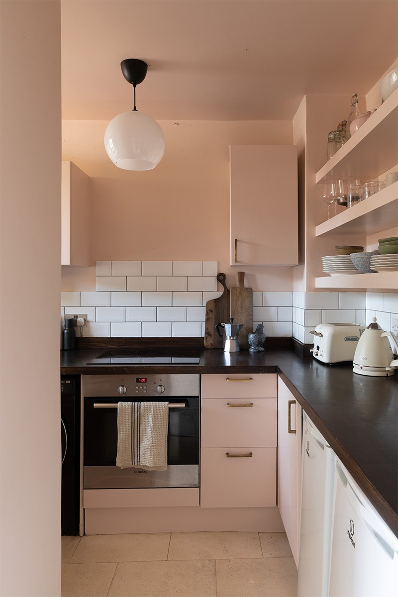 Une cuisine moderne classique rose et un plan de travail noir